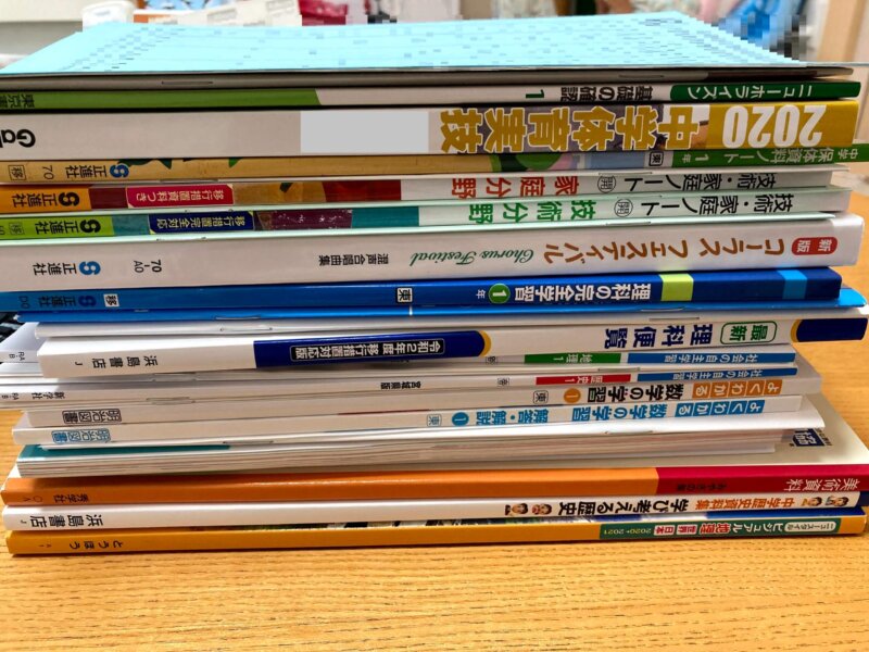 中学校に入学して配付された分厚い教科書類の山