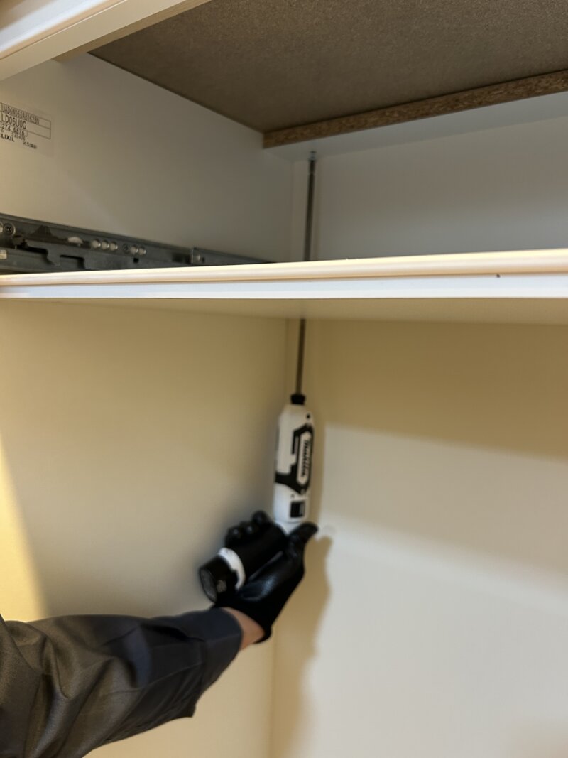 DIY作業中、超ロングドライバーで天板を固定しているリクシルESシリーズのカップボード