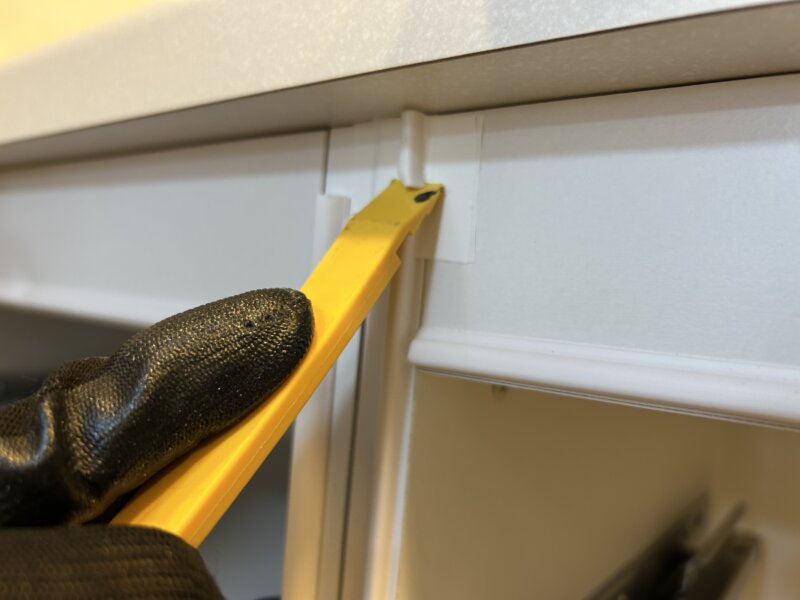 DIY作業中、側板パッキンの切り欠き加工をしているリクシルESシリーズのカップボード