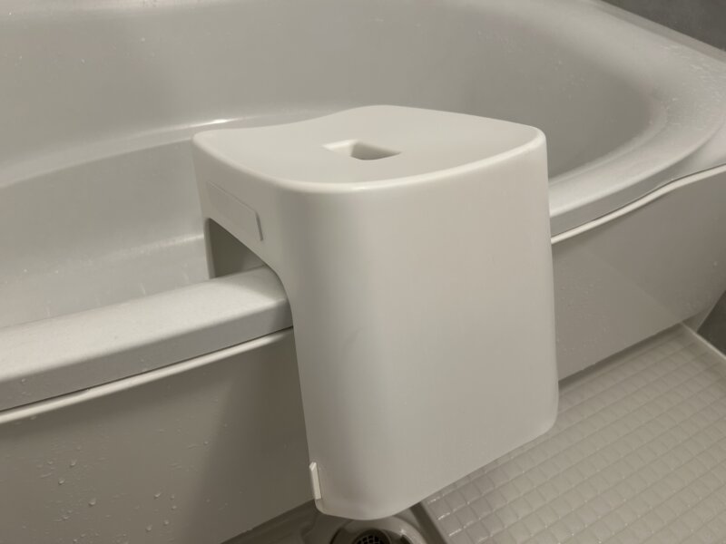 tower洗いやすいマグネット風呂イスを浴槽に引っかけて乾かしているところ